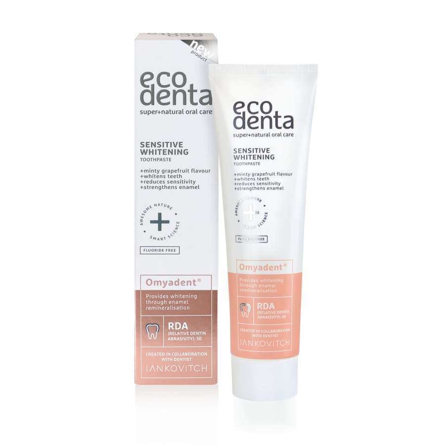 Ecodenta Sensitive Omyadent Valkaiseva Hammastahna; Ecodenta Sensitive Whitening -hammastahna Omyadentilla, rasia ja tuubi, hento greippiaromi ja fluoriton koostumus; suunniteltu valkaisuun ja kiilteen remineralisointiin, pakkaus valkoinen ja persikanvärinen, 100 ml; rasia ja tuubi suorakulmaisia ja lieriömäisiä mattapinnalla, tuubin korkki valkoinen; mustaa groteskitekstiä molemmissa; vaalea tausta, ei ihmisiä tai rekvisiittaa.