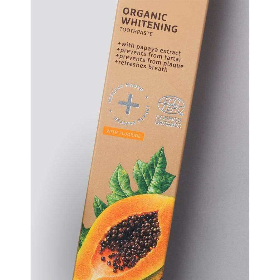 Ecodenta Organic Whitening -hammastahnapakkaus; suorakulmainen, kiiltäväpintainen rasia, väriltään pääosin valkoinen ja oranssi; etiketissä teksti "Organic Whitening" sekä kuva puolikkaasta papaijasta; mainitaan luonnollinen papaijauute, fluoridi, plakin ehkäisy, hammaskiven torjunta ja hengityksen raikastus; ei ihmisiä tai käsiä; vaalea tausta, groteskityyppinen fontti.