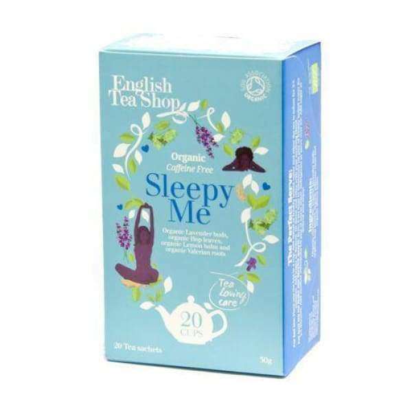 English Tea Shop Luomu Sleepy Me -teepakkaus; sininen, suorakulmainen ja mattapintainen rasia; kuvituksena joogaharjoitusta esittäviä hahmoja sekä laventelia ja muita rauhoittavia yrttejä; sisältää 20 teepussia; merkki ja tuotetiedot valkoisella pääte- ja tekstausvapaalla kirjasimella; kuvattu valkoista taustaa vasten, ei ihmisiä tai käsiä näkyvissä.