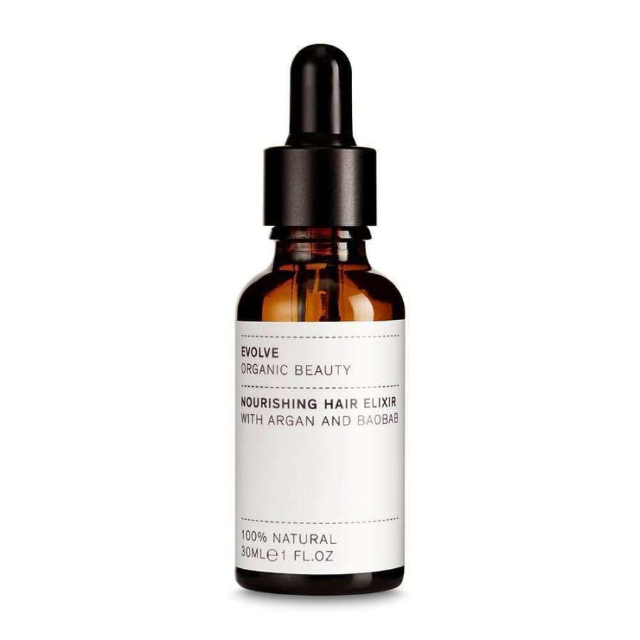 Evolve Nourishing Hair Elixir Kosteuttava Hiusseerumi -tippapullo, 30 ml; ruskea, kiiltäväpintainen lasipullo mustalla tippakorkilla; valkoisessa etiketissä mustaa ja kultaista tekstausvapaata tekstiä, jossa mainitaan arganin ja baobabin sisältö sekä 100-prosenttinen luonnollisuus; kuvattu vaaleaa studiotaustaa vasten suoraan edestä silmän korkeudelta, ei ihmisiä tai käsiä näkyvissä.