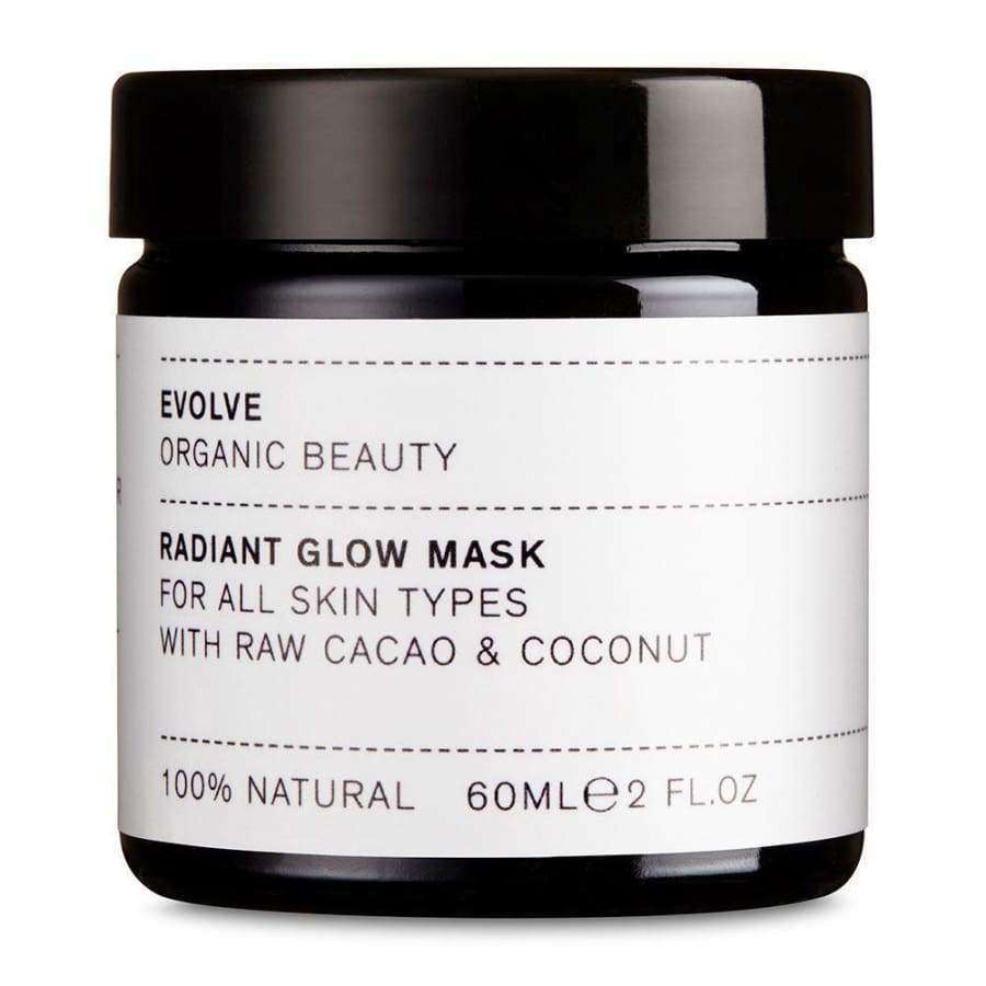 Evolve Radiant Glow Kasvonaamio -purkki, 60 ml; musta, sylinterimäinen ja kiiltäväpintainen purkki; valkoisessa suorakulmaisessa etiketissä tekstausvapaata tekstiä tuotteen soveltuvuudesta kaikille ihotyypeille sekä raakakaakaosta, kookoksesta ja 100-prosenttisesta luonnollisuudesta; kuvattu studiotaustaa vasten, ei ihmisiä tai käsiä näkyvissä.