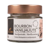 Foodin Bourbon Vaniljauutejauhe -purkki; pieni sylinterimäinen lasipurkki mattapronssisella kierrekannella; etiketti valkoinen mustin ja pronssisin tekstein sekä suomeksi että englanniksi, yksinkertainen vaniljankukkakuvitus; tuotenimessä lukee "Bourbon Vaniljajauhe vanilla extract powder"; serif- ja tekstausvapaata typografiaa sekaisin; ei ihmisiä tai käsiä näkyvissä; neutraali tausta tuotekuvassa.