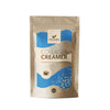 Foodin Collagen Creamer; ruskea, mattapintainen paperipussi tekstillä "Foodin Collagen Creamer" sinisin korostuksin, seisoo pystyssä valkoisella taustalla; pakkauksessa yksinkertainen kahvikuppikuvake ja suomenkielistä tekstiä selkeällä groteskifontilla; ei ihmisiä tai käsiä; suoraviivainen tuotekuva.
