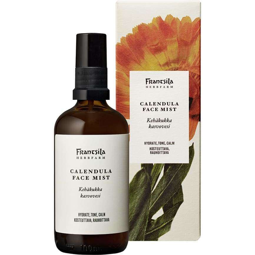 Frantsila Calendula Face Mist -kasvovesi; ruskea suihkepullo pystyssä suorakulmaisen pahvirasian edessä; rasiassa kuva oranssista kehäkukasta vihreine varsineen ja lehtineen sekä selkeää, modernia groteskityyppiä tuotetiedoille; molemmat vaalealla taustalla tasaisessa valaistuksessa; ei ihmisiä tai käsiä.