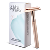 The Original Geisha Shaver -parranajokone; ruusukultainen partakone pystyssä pakkauksensa vieressä; partakoneen pinta kiiltävä metallinen, kahva perinteisen lieriömäinen; suorakulmainen rasia pääosin valkoinen, vaaleansinisin ja hopeanvärisin yksityiskohdin, groteskitekstiä; molemmat esineet vaalealla, tasaisella taustalla; ei ihmisiä tai käsiä.