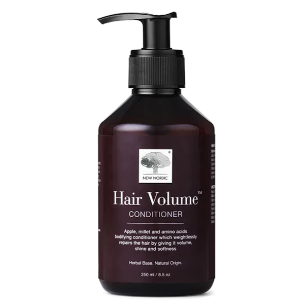 Hair Volume hoitoaine; suorakulmainen, pyöristettyreunainen ja kiiltäväpintainen pullo pumppuannostelijalla, tumma etiketti valkoisin tekstein; sisältö 250 ml; mainitaan omena, hirssi ja aminohapot; neutraali tausta.