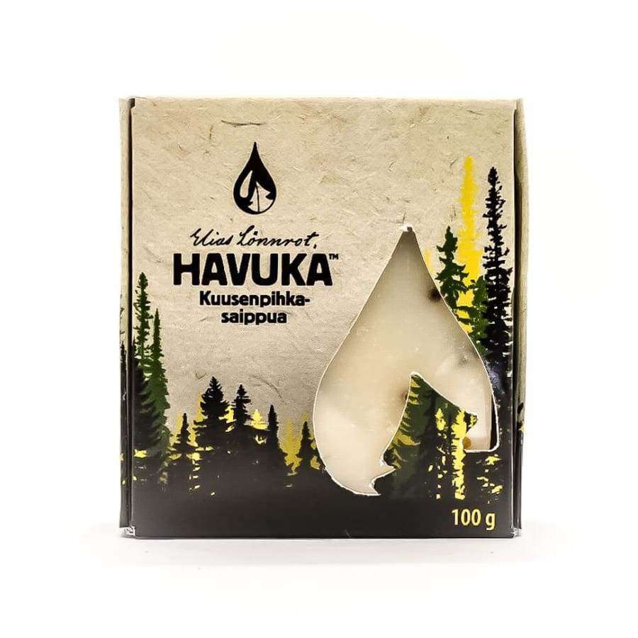 Havuka Kusenpihkasaippua -pakkaus, 100 g, kuvassa puiden siluetteja ja läpinäkyvä pisaranmuotoinen ikkuna, jonka läpi näkyy mäntyisen tuoksuinen saippua; laatikko suorakulmainen mattapahvia, luonnollisen ruskea väri ja painettuja mustia grafiikoita; typografia lihavoitua ja suuraakkosin; tuote kuvattu valkoista taustaa vasten, ei ihmisiä tai käsiä näkyvissä.