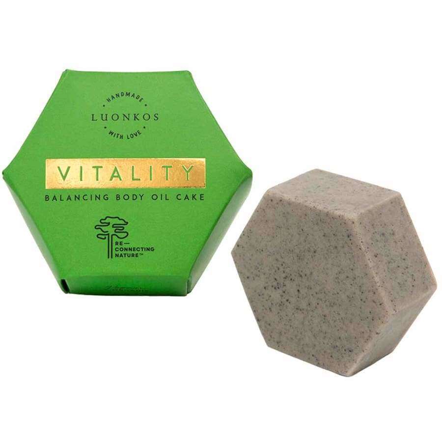 Luonkos VITALITY Vartaloöljykakku; kuusikulmainen vihreä rasia tekstillä "Luonkos Vitality Balancing Body Oil Cake" vastaavan kuusikulmaisen, pilkullisen ja ravitsevan kiinteän vartaloöljykakun vieressä valkoisella taustalla; rasia mattapintainen, mustaa ja kultaista groteskitypografiaa, taitettava rakenne; öljykakku vaaleansävyinen näkyvin tummin täplin ja sileä pinnaltaan; ei ihmisiä tai käsiä tuotekuvassa.