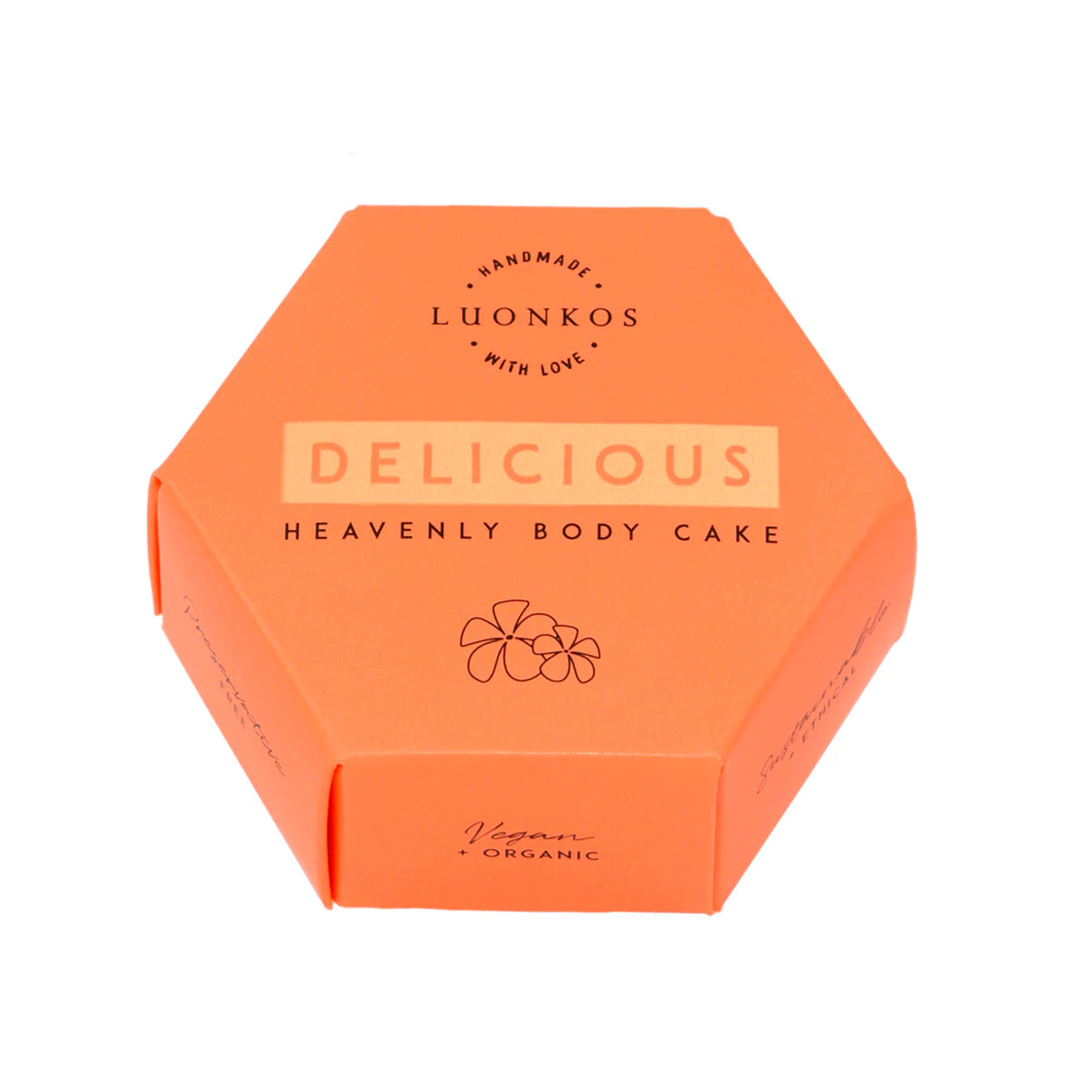 Luonkos Delicious Heavenly Body Cake; kuusikulmainen oranssi rasia mattapinnalla; pakkauksessa lohko- ja käsialafontteja sekä pieni kukkakuvitus keskellä etusivua; tekstissä mainitaan käsintehty, vegaaninen ja luomu; ei ihmisiä tai käsiä; neutraali tausta, yksittäinen tuote kuvassa; rasian materiaali vaikuttaa pahvilta.