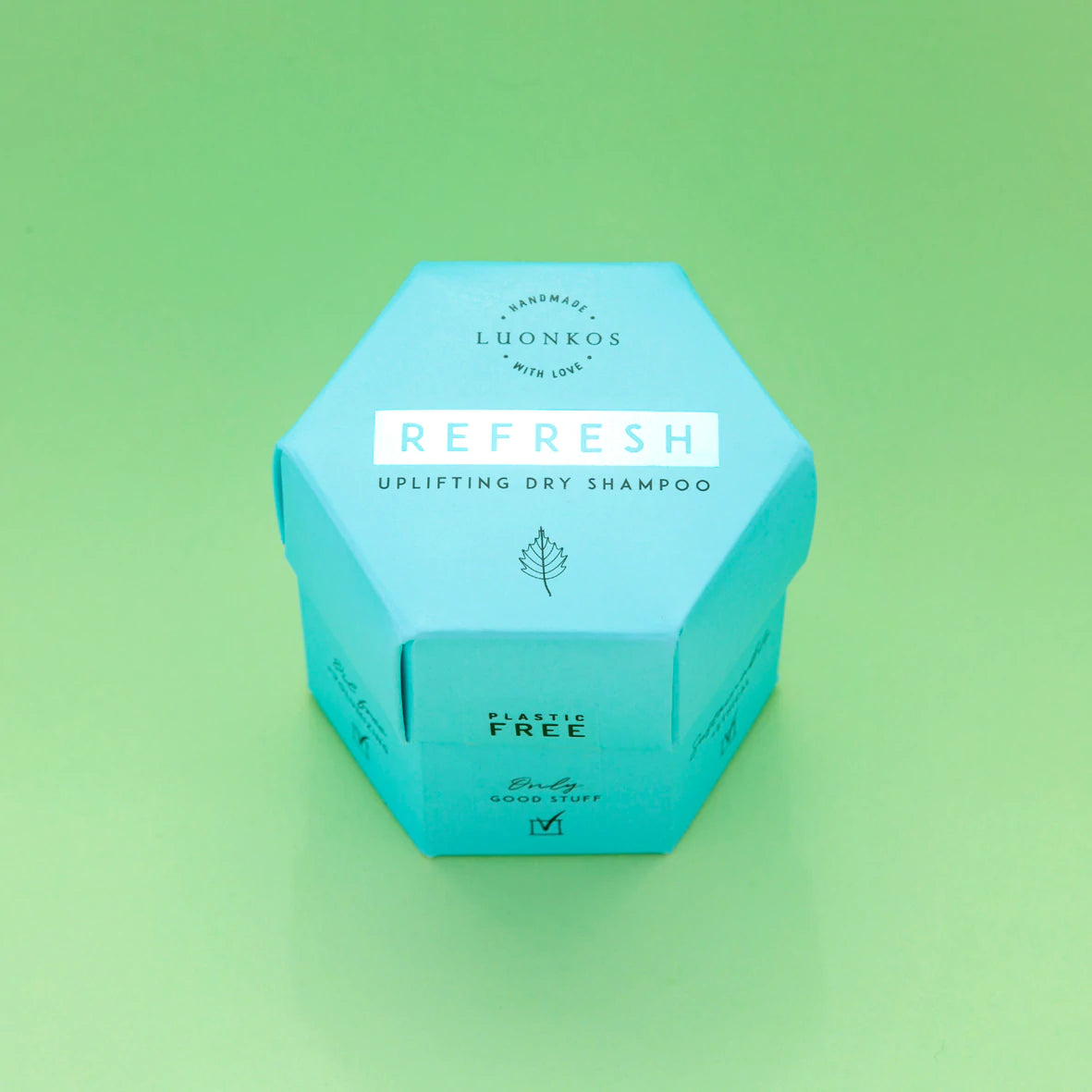 Luonkos REFRESH Kuivashampoo; kuusikulmainen turkoosi rasia tekstillä "REFRESH Uplifting Dry Shampoo" vihreää taustaa vasten; pakkaus pahvia mattapinnalla, groteskityyppiä valkoisena ja kultaisena; luettavissa oleva teksti sisältää "Plastic Free", "Handmade with love", "Luonkos"; ei ihmisiä kuvassa, tuote keskitettynä kuvaan.