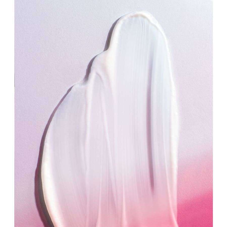Madara Derma Collagen Hydra-Silk Firming Kasvovoide; lähikuva kermaisesta valkoisesta puhdistusaineesta levitettynä sileälle, tasaiselle pinnalle, väri muuttuu pehmeän vaaleanpunaiseksi alareunassa; pinta kiiltävä ja kostea; valaistus hajautettu korostaen tekstuuria ja kiiltoa; ei näkyviä etikettejä, pakkausta, tekstiä, ihmisiä tai muita esineitä kuvassa.
