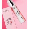 Madara Derma Collagen Hydra-Silk Firming Kasvovoide; Mádara Derma Collagen Hydra-Silk Firming Cream -pullo ja rasia kaikille ihotyypeille vaaleanpunaisella taustalla; pakkaus koostuu lieriömäisestä pullosta pumpulla ja suorakulmaisesta rasiasta, molemmat mattavaaleita; tuote- ja brändinimi painettu selkeällä, lihavoidulla mustalla groteskitekstillä; ei ihmisiä tai käsiä kuvassa.