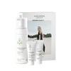 MÁDARA-ihonhoitosetti, sisältäen Purifying Foam-, Deep Moisture Fluid- ja Regenerating Cream -tuotteet, aseteltu pystyyn pahvirasian eteen. Astiat ovat valkoisia ja lieriömäisiä mattapinnalla ja minimalistisin mustin pääteviivattomin tekstein. Pakkauksessa on kuva mustapukuisesta naisesta seisomassa hiekkarannalla pilvisen taivaan alla.