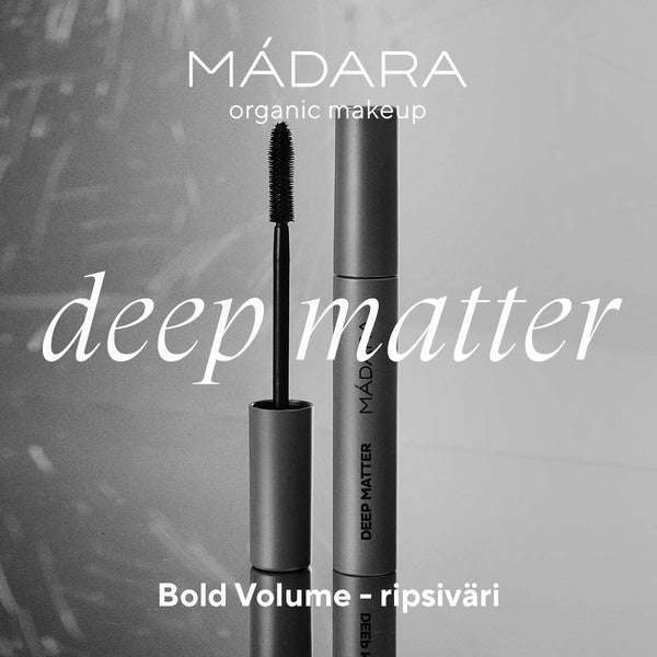 Madara DEEP MATTER Bold Volume Ripsiväri; tuubi ja siihen kuuluva harja vierekkäin, molemmat sylinterinmuotoisia ja sileäpintaisia; kuva mustavalkoinen, tuotenimi ja "Bold Volume ripsiväri" selkeällä groteskikirjasimella tuubissa; ei ihmisiä tai käsiä; tausta neutraali ilman näkyvää ympäristöä tai rekvisiittaa.