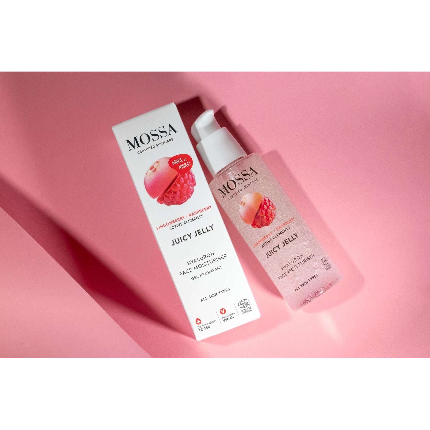Mossa Juicy Jelly Hyaluronihapposeerumi, puolukka ja vadelma, kosteuttava hyaluronihappo; pullo ja pakkaus vaaleanpunaisella taustalla pystyssä; pullo puoliläpinäkyvä valkoisella korkilla, pakkaus suorakulmainen valkoisella pinnalla ja värikkäällä tekstillä; tuotenimi selkeästi luettavissa groteskikirjasimella; ei ihmisiä tai käsiä kuvassa.