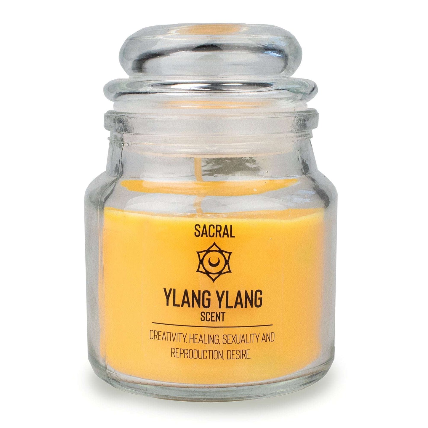 Myga Chakra Tuoksukynttilä; keltainen ylang ylang -tuoksuinen kynttilä kirkkaassa lasipurkissa, etiketissä teksti "Sacral"; purkki suorareunainen ja tasapohjainen, pinta kiiltävä ja läpinäkyvä; etiketin teksti lihavoidulla oranssilla groteskikirjasimella, mainiten luovuuden, parantumisen ja halun; keskitetty tuotekuva vaalealla taustalla, ei ihmisiä tai käsiä.
