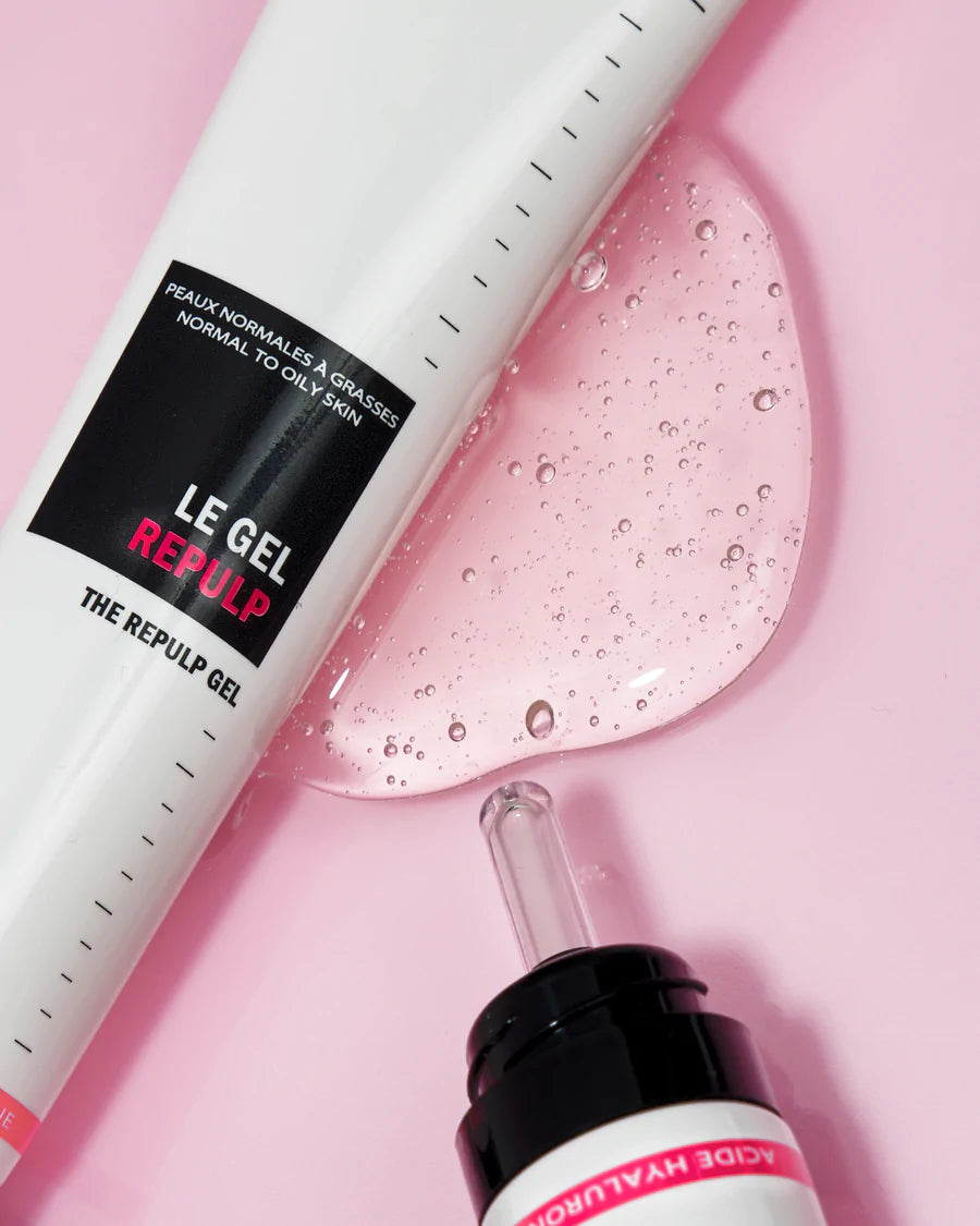 Novexpert HYALURONIC The Repulp Gel; tuubi tekstillä "Le Gel Repulp" ja tiputinpullo kirkkaan vaaleanpunaisen geelin kera vaaleanpunaisella taustalla; molemmat pakkaukset muovia kiiltäväpintaisena, tuubi sylinterinmuotoinen ja pullo pyöreä musta korkki; geeliä levitetty kaarevasti molempien alle; ei ihmisiä tai käsiä kuvassa.