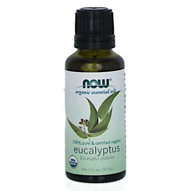 Now Foods Luomu Eucalyptusöljy -pullo, musta korkki, vihreä etiketti eukalyptuslehtikuvituksin; kiiltäväpintainen sylinteri, lihavoitu ja tavallinen groteskiteksti, "100% pure" ja "certified organic"
