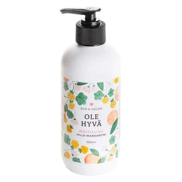 Ole Hyvä Hoitoaine Hilla-Mandariini -pumppupullo, 350 ml; valkoinen, kiiltäväpintainen muovipullo pyöristetyllä olkaosalla; mattapintaisessa etiketissä lihavoitu teksti "OLE HYVÄ" suuraakkosin, värikkäitä kukka- ja hedelmäkuvituksia sekä pienempää kuvaustekstiä; kuvattu vaaleaa taustaa vasten, ei ihmisiä tai käsiä näkyvissä.