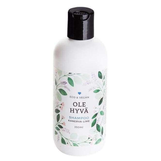 OLE HYVÄ Shampoo Kanerva-Lime -pullo, 350 ml; valkoinen, mattapintainen muovipullo mustalla kierrekorkilla; etiketissä vihreitä lehtigrafiikoita ja tuotenimi selkeällä tekstausvapaalla kirjasimella; merkinnät eco & vegan; kuvattu keskisuurena lähikuvana neutraalia taustaa vasten, ei ihmisiä tai käsiä näkyvissä.