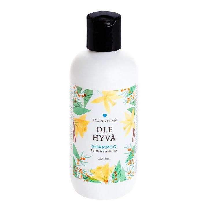 Ole Hyvä Shampoo Tyrni-Vanilja; valkoinen pullo kukkakuvituksin, musta muovikorkki, mattapinta; pullo lieriömäinen pyöristetyin olkapäin; etiketissä teksti "Eco & Vegan", "Ole Hyvä Shampoo Tyrni-Vanilja", 350 ml, selkeällä groteskifontilla; ei ihmisiä tai käsiä; vaalea tausta, tuote keskitetty kuvaan.