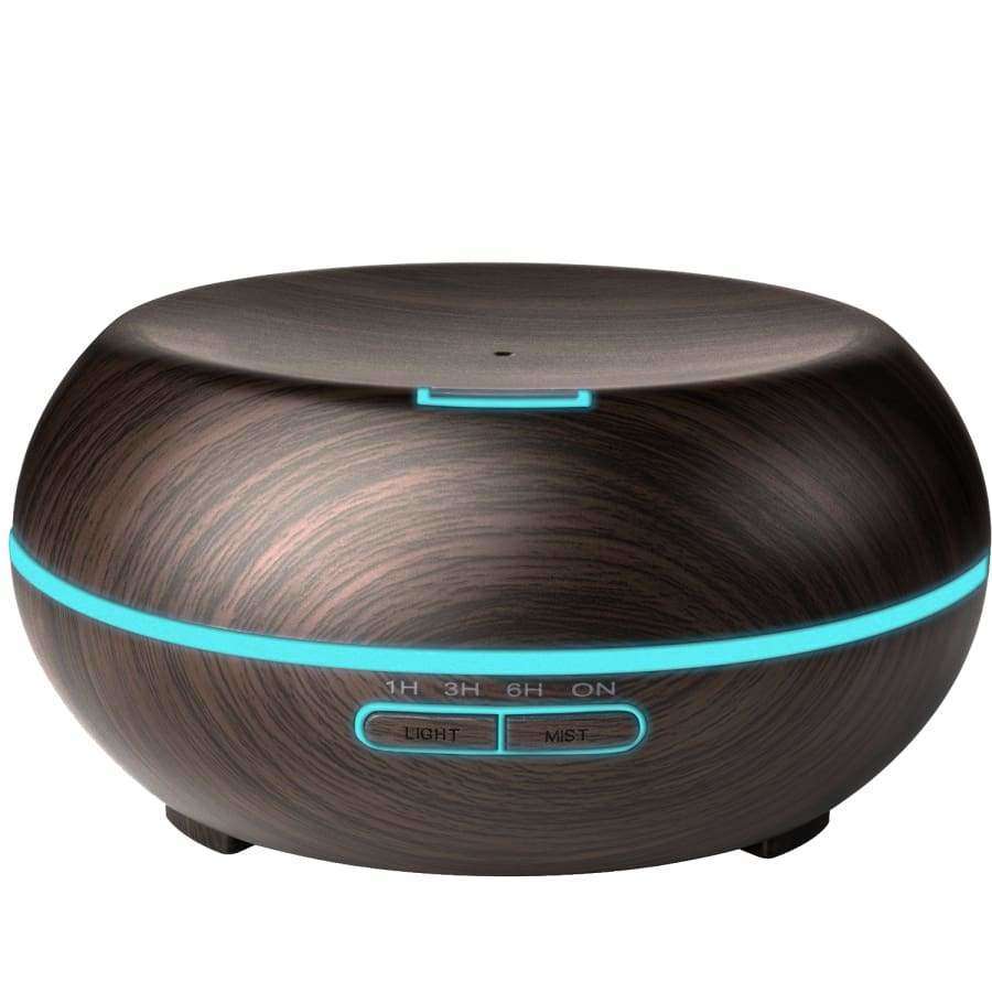 Puhdas+ Aroma Diffuser AD-9 -tuoksuhajotin, pyöreä tummapuinen laite, jossa sininen LED-valorengas ja painikkeet LIGHT ja MIST etupuolella; pinta mattapintainen näkyvin puukuvioin; ei pakkausta tai brändäystä näkyvissä; molemmat painikkeiden merkinnät suuraakkosin tekstausvapaalla fontilla; tausta valkoinen, keskitetty tuotelähikuva, ei ihmisiä tai käsiä näkyvissä.