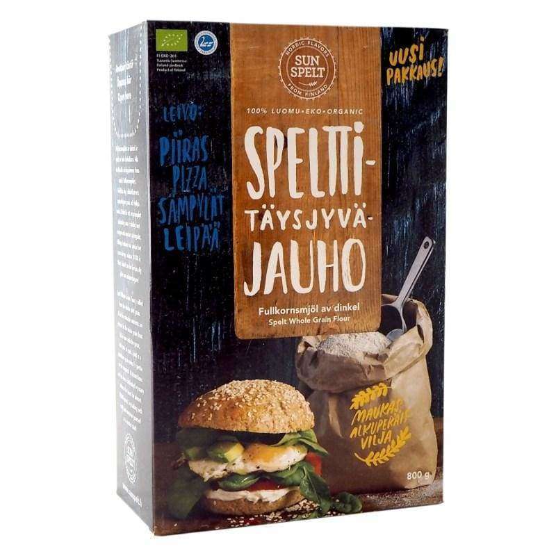 SunSpelt Luomu Spelt Täysjyväjauho; suomen- ja englanninkielistä tekstiä pakkauksessa; suorakulmainen rasia mattapinnalla, pääosin valkoinen ja oranssi; etusivulla kuva voileivästä salaatin ja tomaatin kanssa sekä ruskea jauhosäkki metallisella kauhalla; lihavoitua groteskitypografiaa selkeästi luettavissa mustavalkoisena; ei ihmisiä tai käsiä; vaalea harmaa tausta, kuvattu suoraan edestä tasaisessa valaistuksessa.