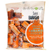 Superfudgio Luomu Suolakaramellifudge; pussi tekstillä "Super Fudgio vegan salted caramel fudges", oranssi pakkaus; mattapintainen pussi tyylitellyin tekstein ja kuvakkein vegaanisuudesta, luonnonmukaisuudesta, gluteenittomuudesta, palmuöljyttömyydestä sekä kookossokerista ja kookosjauheesta; pussimainen ja saumasuljettu yläosa; ei ihmisiä tai käsiä, pelkkä tuote etupuolelta kuvattuna.