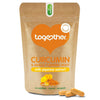 Together Health Curcumin Complex; ruskea mattapintainen joustopussi tekstillä "Curcumin & Whole Turmeric Root" piperiiniuutteella, pystyssä valkoisella taustalla; oranssi sydänlogo ja teksti luonnollisista ainesosista selkeällä groteskikirjasimella; vieressä kolme keltaista kapselia ja pieni kasa oranssia jauhetta, kaksi kapselia etureunalla.