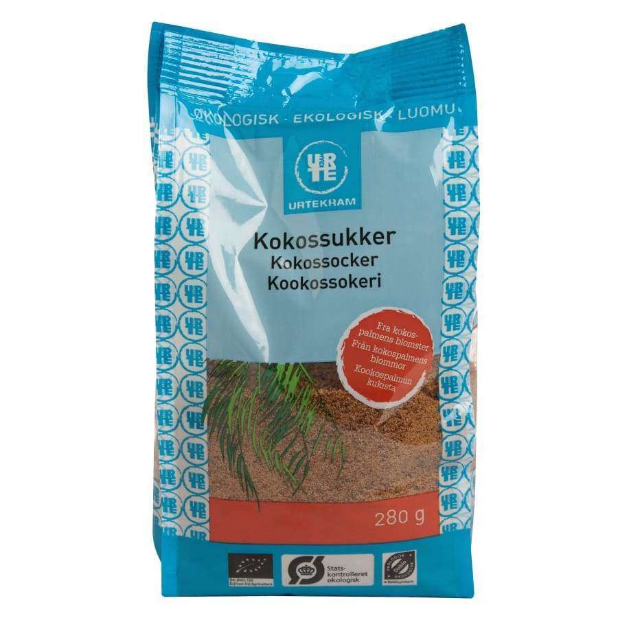 Urtekram Luomu Kookossokeri -pakkaus, 280 g, sininen-valkoinen mattamuovi, tasapohjainen; teksti useilla kielillä, tuotenimi, logo, paino ja kuvaus, yksinkertaiset ruoho- ja kookoskuvat