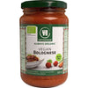 Urtekram Vegan Bolognese -kastikepurkki, 350 g, soijapohjainen; sylinterimäinen kirkas lasipurkki metallisella kiertokannella; mattapintaisessa etiketissä vihreää ja punaista, valkoista ja mustaa tekstausvapaata tekstiä, merkintä "Always Organic"; etiketissä kuva pastasta tomaattikastikkeen kanssa sekä luomusertifiointimerkkejä; kuvattu valkoista studiotaustaa vasten, ei ihmisiä tai käsiä näkyvissä.