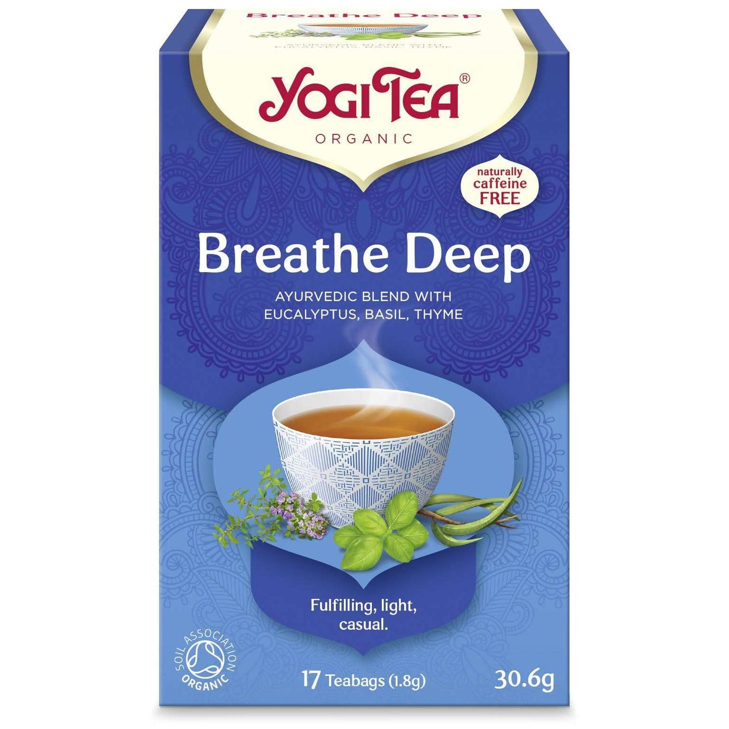 YogiTea Luomu Breathe Deep -teepakkaus; sininen, suorakulmainen ja mattapintainen rasia; etiketissä kuva höyryävästä teekupista sekä basilikaa ja timjamia; valkoista ja kultaista päätekirjasinta käyttävä teksti kertoo ayurvedisesta yrttiseoksesta eukalyptuksen, basilikan ja timjamin kanssa, kofeiinittomuudesta ja 17 teepussista; kuvattu yksiväristä taustaa vasten lähikuvana, ei ihmisiä tai käsiä näkyvissä.