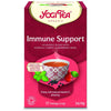 YogiTea Luomu Immune Support tee; rasia tekstillä "Yogi Tea Immune Support", teekuppi, yrttejä ja marjoja sekä teksti korostaa ayurvedista sekoitusta asserola-kirsikasta, mustaseljasta ja basilikasta; rasiassa mainitaan luonnollinen C-vitamiini ja 17 teepussia (34 g); suorakulmainen mattapintainen pakkaus oranssin-keltaisin sävyin; selkeää lihavoitua tekstiä etuosassa; vaalea tausta, ei ihmisiä näkyvissä.