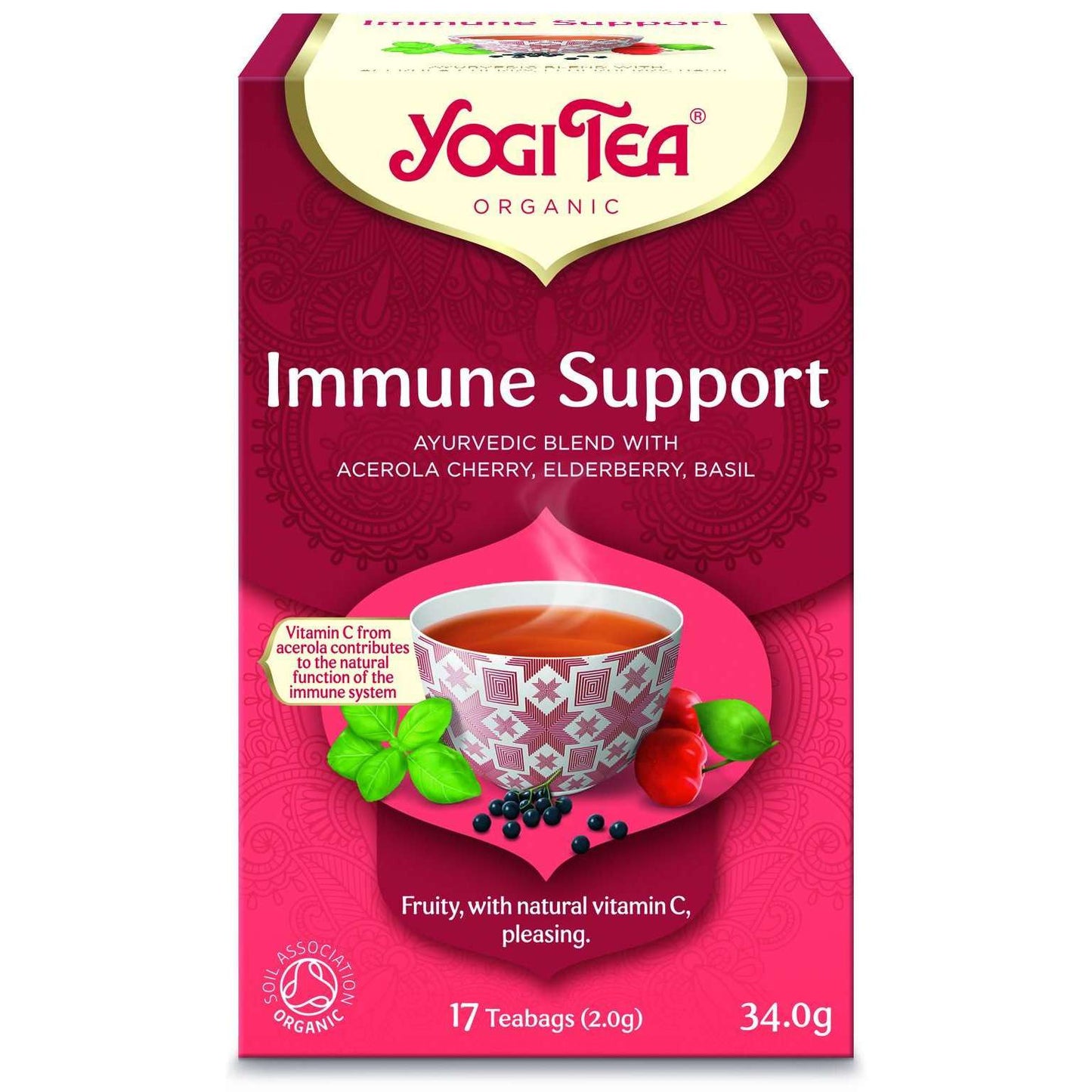 YogiTea Luomu Immune Support tee; rasia tekstillä "Yogi Tea Immune Support", teekuppi, yrttejä ja marjoja sekä teksti korostaa ayurvedista sekoitusta asserola-kirsikasta, mustaseljasta ja basilikasta; rasiassa mainitaan luonnollinen C-vitamiini ja 17 teepussia (34 g); suorakulmainen mattapintainen pakkaus oranssin-keltaisin sävyin; selkeää lihavoitua tekstiä etuosassa; vaalea tausta, ei ihmisiä näkyvissä.