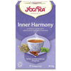 YogiTea Luomu Inner Harmony -teepakkaus; suorakulmainen, mattapintainen ja violetti rasia; kuvituksena teekuppi, sitruunamelissa, rooibos-oksia ja kanelitankoja; valkoista ja keltaista koristeellista tekstiä; pakkaus kuvataan luomu-ayurvedisena teeseoksena; ei ihmisiä tai ympäristöä näkyvissä.