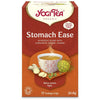 YogiTea Luomu Stomach Ease -teepakkaus, suorakaiteen muotoinen, mattapintainen, oranssi-ruskea; teekuppi pakkauksen vieressä, tuoretta inkivääriä, kardemumman siemenkotia ja fenkolinsiemeniä esillä; ayurvedinen sekoitus, kofeiiniton, 17 pussia (30,6 g)